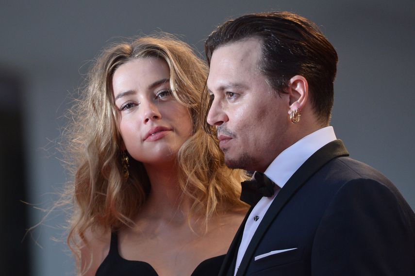 En esta foto de archivo tomada el 4 de septiembre de 2015, el actor estadounidense Johnny Depp y su esposa, la actriz estadounidense Amber Heard, llegan para la proyección de la película Black Mass presentada fuera de competencia en el 72° Festival Internacional de Cine de Venecia el 4 de septiembre de 2015 en el Lido de Venecia. La demanda contra un tabloide podría pasar factura para ambos.&nbsp;