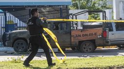 Un oficial de policía de México pone cinta amarilla para asegurar la escena del crimen.