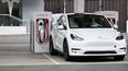 Un auto Tesla recarga sus baterías en una estación.