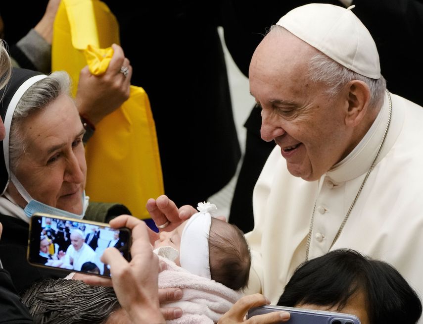El papa Francisco saluda a un recién nacido al cabo de su audiencia general semanal en la sala Pablo VI, Vaticano, 1 de diciembre de 2021.&nbsp;