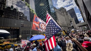 Un partidario del expresidente Donald Trump ondea una bandera estadounidense invertida durante una manifestación frente a la Torre Trump.