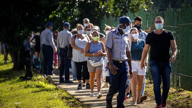 Gente con mascarillas en medio de la pandemia del nuevo coronavirus se forma para entrar a una tienda de alimentos que acepta d&oacute;lares estadounidenses en La Habana, Cuba, el lunes 20 de junio de 2020.