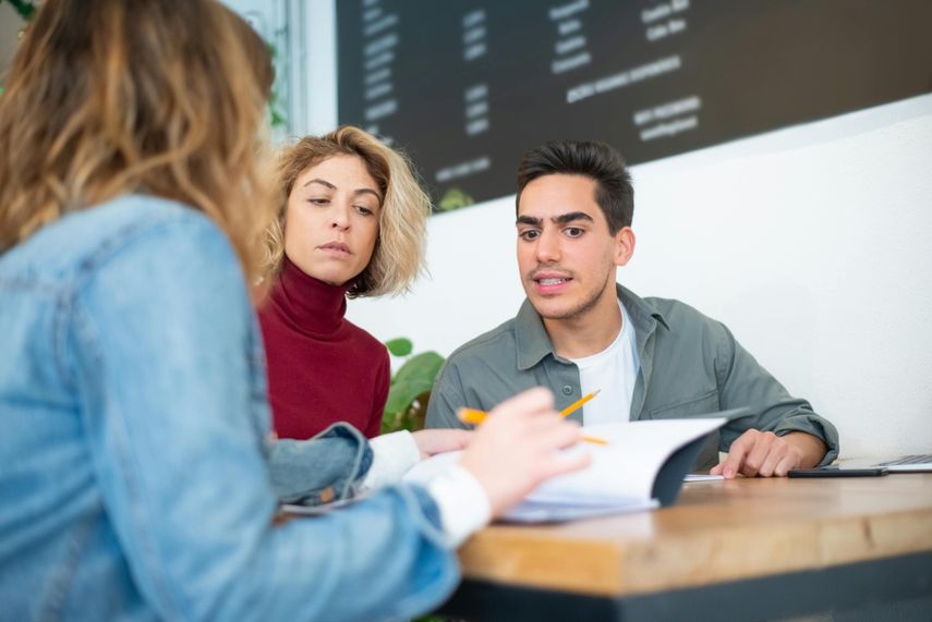 Tres personas hablan sobre negocios