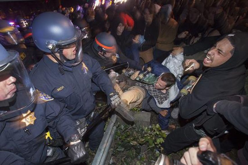 Manifestantes se enfrentan a la policía durante una protesta en Oakland, el 24 de noviembre de 2014.  EL presidente Obama dijo que los actos destructivos son un crimen. (AP)
