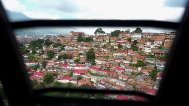 Una turista toma una foto a bordo de un teleférico durante un recorrido organizado por Cumbe Tour, en el barrio San Agustín de Caracas, Venezuela.