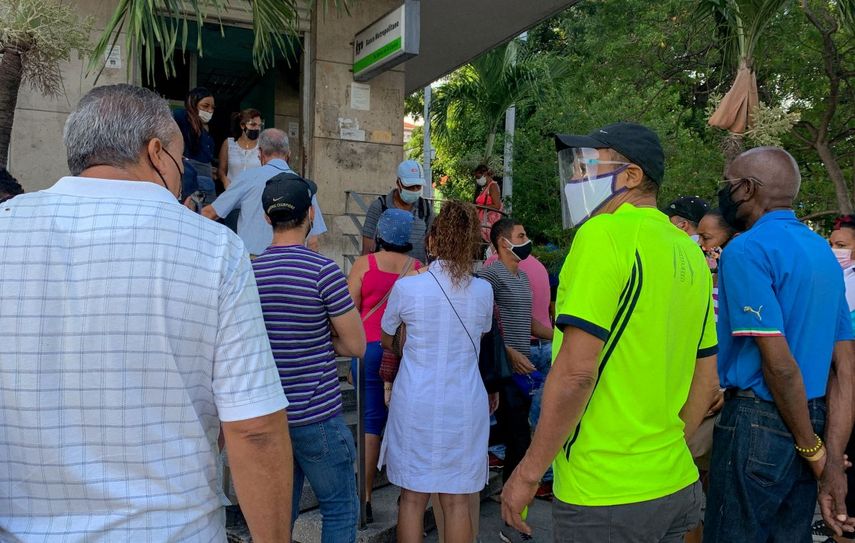 La gente hace fila frente a una sucursal bancaria en La Habana para depositar dólares estadounidenses antes de que entre en vigencia un nuevo decreto que suspenderá dichos depósitos en los bancos de Cuba.
