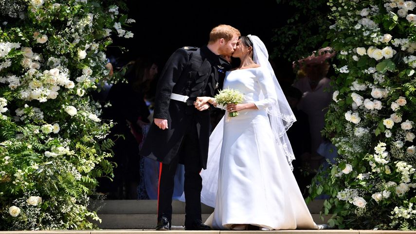 En esta foto de archivo tomada el 19 de mayo de 2018, el príncipe Harry, duque de Sussex, besa a su esposa, Meghan Markle, cuando salen de la puerta oeste de la capilla de San Jorge en el castillo de Windsor después de su ceremonia de boda.
