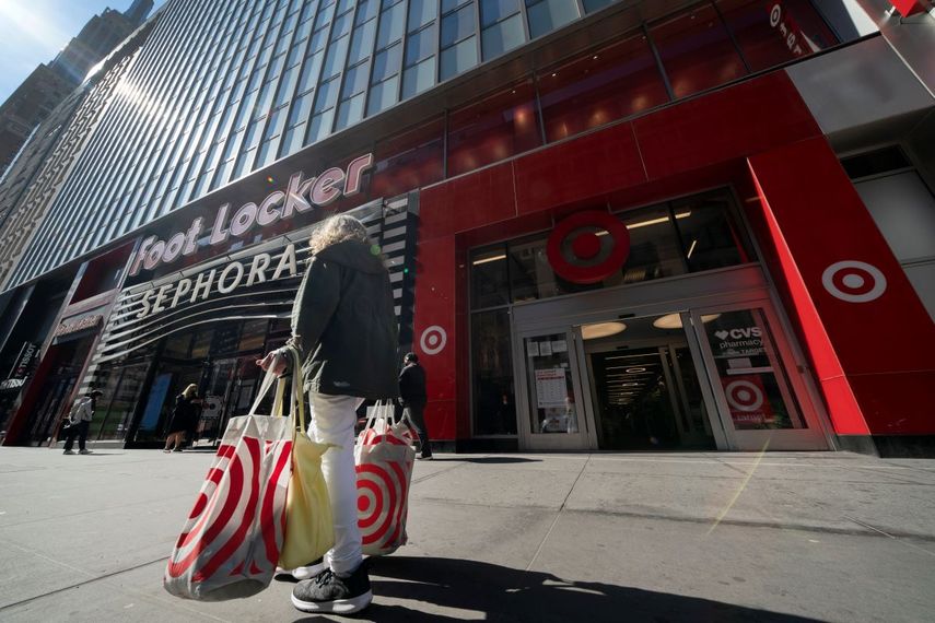 Una persona con bolsas de compra frente a la entrada de una tienda Target.