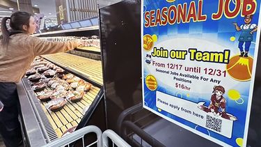 Un letrero solicita trabajadores temporarales en una tienda de alimentos en Arlington Heights, Illinois.