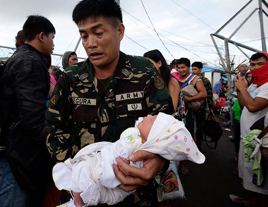 Un soldado traslada a Ian Daniel Honrado, de un día de nacido, a un avión militar en el aeropuerto de Tacloban, Filipinas. (Foto AP/Bullit Marquez)