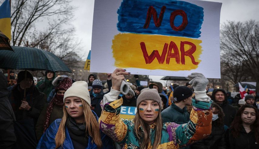 Jóvenes prostestan ante la Embajada de Rusia en Estados Unidos, contra la invasión a Ucrania.