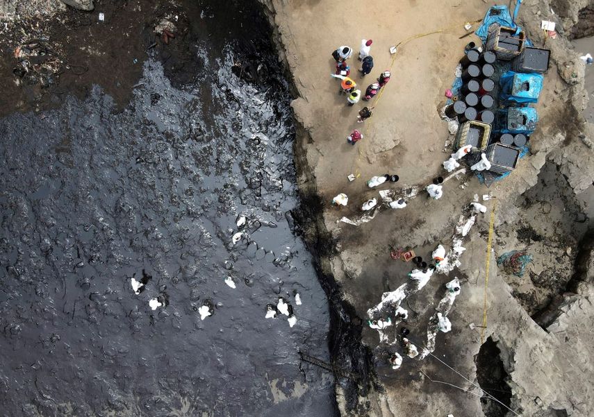 Los trabajadores continúan en una campaña de limpieza después de un derrame de petróleo, en Playa Cavero en el distrito de Ventanilla de Callao, Perú, el sábado 22 de enero de 2022.
