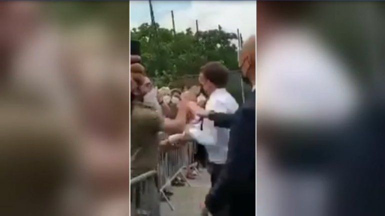 Captura de pantalla de video en el momento que el presidente Emmanuel Macron recibe una bofetada de un individuo.