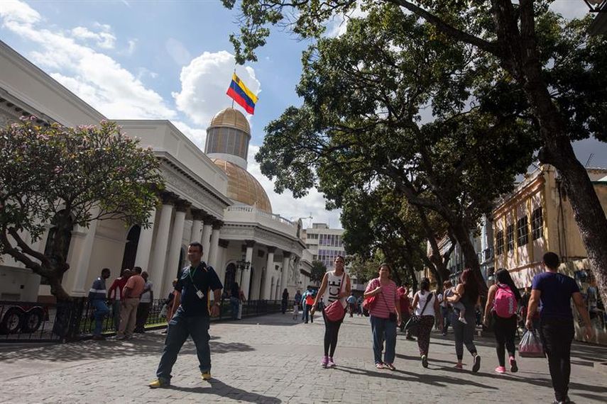 Transeúntes caminan frente a la sede de la Asamblea Nacional (AN) en Caracas,Venezuela.(EFE)