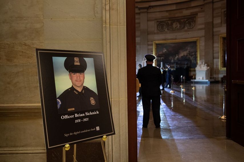 Una imagen del difunto policía del Capitolio de Estados Unidos Brian Sicknick, mientras la gente espera a que una urna con sus restos cremados sea llevada al Capitolio para ser depositada allí.&nbsp;