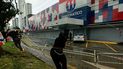 Los manifestantes derriban una barrera en la sede del Partido Revolucionario Democrático (PRD) durante una protesta contra el alto costo de los alimentos y la gasolina en la Ciudad de Panamá, el 20 de julio de 2022
