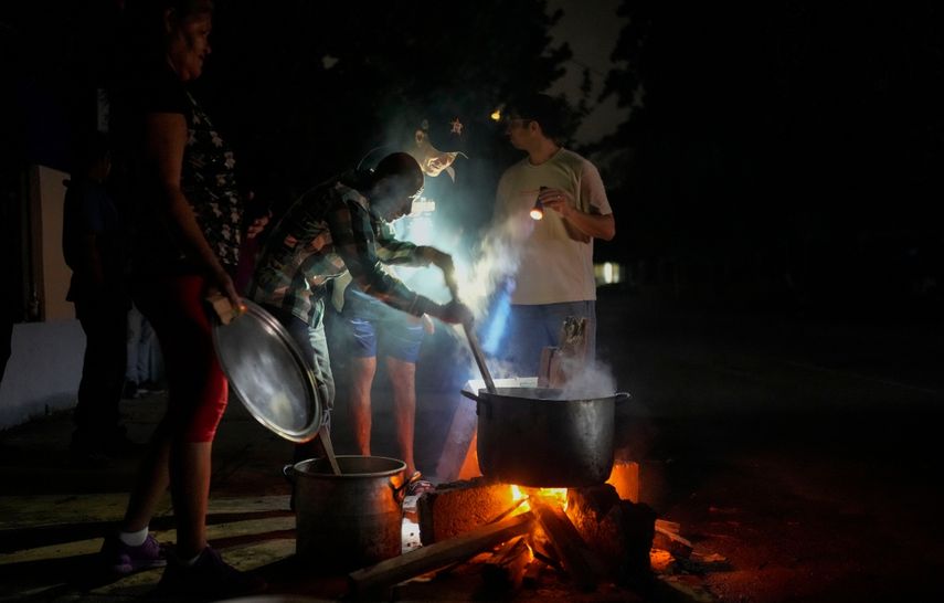 Personas preparan una sopa en una fogata durante un apagón que siguió a la falla de una importante planta energética en La Habana, Cuba, el sábado 19 de octubre de 2024.