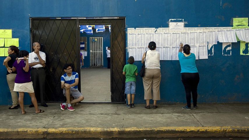 Ciudadanos nicaragüenses se buscan en la lista del padrón electoral en una de las juntas receptoras de votos en Managua este domingo 6 de noviembre de 2016, durante los comicios generales en Nicaragua.