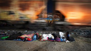 Migrantes, en México, duermen junto a las vías ferroviarias mientras esperan un tren hacia el norte que se detenga tiempo suficiente para poder subir.