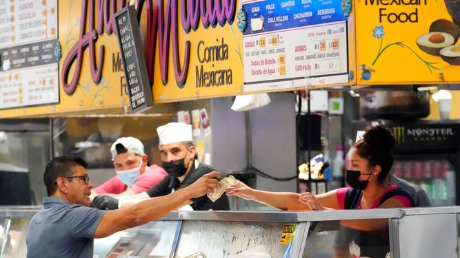 Un cliente paga su comida en un restaurante de comida rápida.