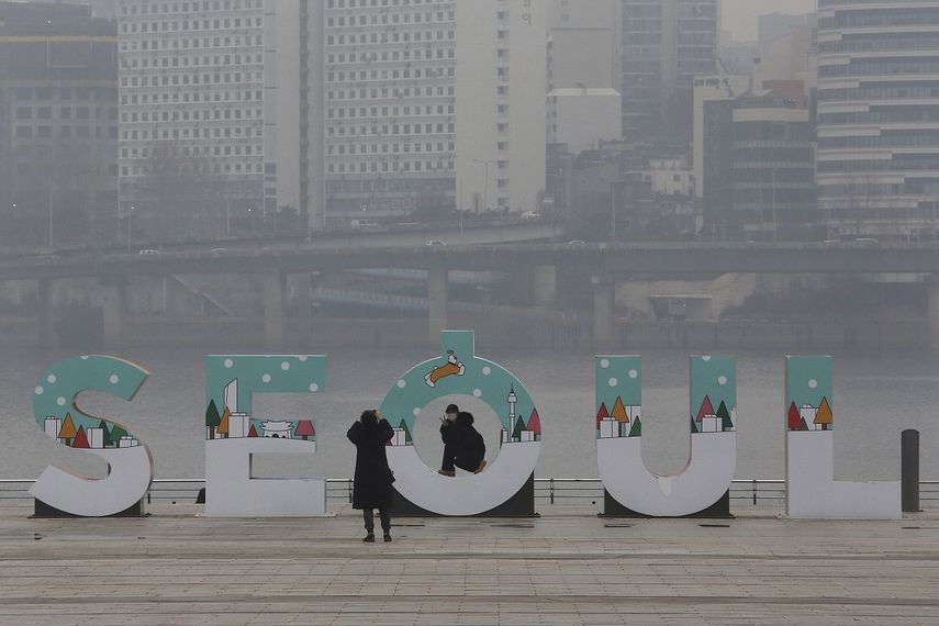 Una mujer con mascarilla para reducir los contagios de coronavirus posa para una foto en un parque de Seúl, Corea del Sur, el martes 26 de enero de 2021.