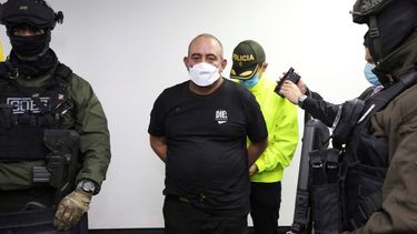 En esta foto proporcionada por la Oficina de Prensa de la Policía de Colombia, uno de los narcotraficantes más buscados del país, Dairo Antonio Úsuga, alias Otoniel, es esposado a su llegada a Bogotá, Colombia, el sábado 23 de octubre de 2021