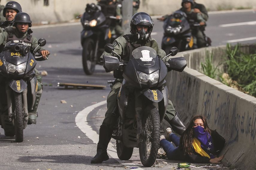 Un efectivo de la Guardia Nacional Bolivariana reprime a una estudiante durante una de las protestas opositoras en Caracas.