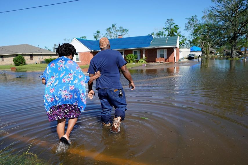 Soncia King y su esposo Patrick King cruzan una calle inundada en Lake Charles, Louisiana, EEUU, 10 de octubre de 2020, después del paso del huracán Delta.