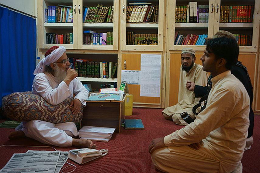 Maulana Abdul Aziz, el clérigo jefe de un paquistaní de seminario, charla con un visitante en una biblioteca que lleva el nombre de asesinado líder de Al Qaeda, Osama Bin Laden. (AP)
