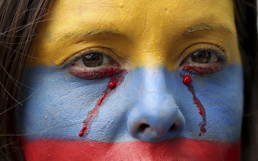 Fotograf&iacute;a del 27 de noviembre de 2019 de una mujer con el rostro pintado con los colores de la bandera de Colombia.