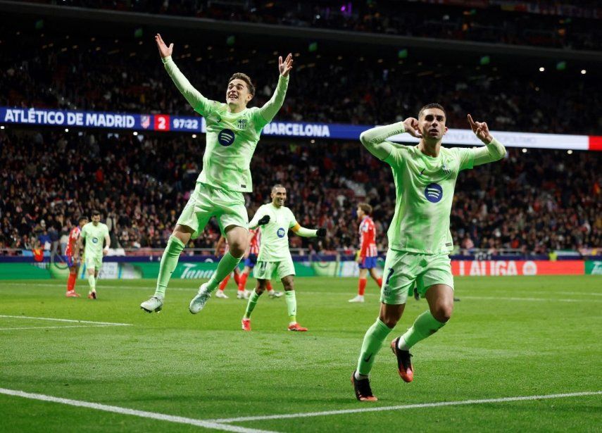 El centrocampista español del Barcelona, Pablo Gavi, y el delantero español del Barcelona, Ferran Torres, celebran la victoria al final del partido de la liga española entre el Club Atlético de Madrid y el FC Barcelona en el Estadio Metropolitano de Madrid, el 16 de marzo de 2025. El Barcelona ganó 2-4.&nbsp;