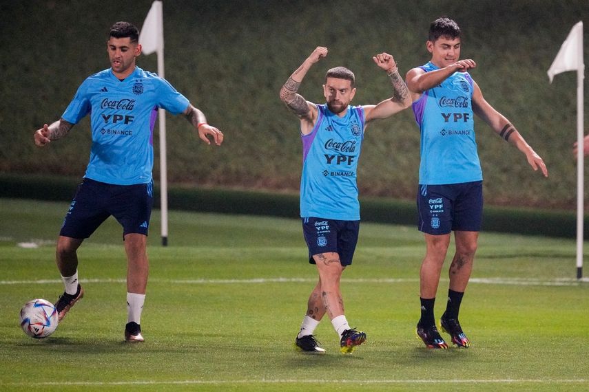 Cristian Romero, izquierda, Alejandro Gómez, centro, y Paulo Dybala calientan durante una sesión de entrenamiento de la selección argentina de fútbol en la Universidad de Catar, en Doha, el viernes 18 de noviembre de 2022.&nbsp;