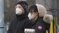 Residentes se protegen con una mascarilla facial mientras esperan en un sem&aacute;foro en Beijing, China, el 13 de febrero de 2020.&nbsp;