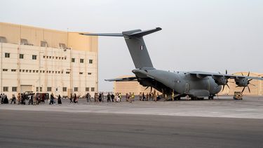 Personas caminan sobre la pista al desembarcar de un avión de transporte militar Airbus A400M en la base militar francesa 104 en Abu Dhabi, el 23 de agosto de 2021, luego de ser evacuadas de Kabul como parte de la operación Apagan.    