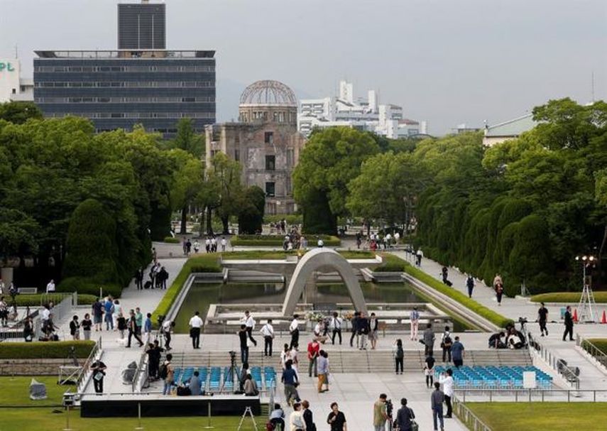Visitantes caminan por el Parque de la Paz de Hiroshima con la Cúpula de la Bomba Atómica al fondo en Hiroshima (EFE)