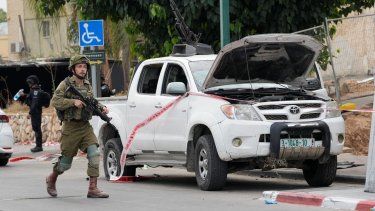 Un soldado israelí pasa junto a una camioneta utilizada por milicianos palestinos en Sderot, Israel, el sábado 7 de octubre de 2023. 