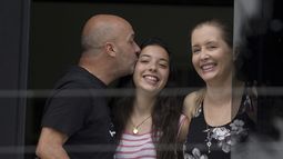 En esta imagen del 20 de septiembre de 2014 se ve a Iván Simonovis, exjefe de la policía de Caracas, mientras le da un beso a su hija Ivana, a un costado de su esposa Bony, mientras se asoman por una ventana en su residencia de Caracas, Venezuela, en donde pasó casi cinco años bajo arresto domiciliario.