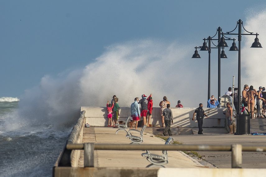 Un polic&iacute;a de Key West (al centro) ordena a visitantes que desalojen el muelle Edward B. Knight el lunes 24 de agosto de 2020, en Key West, Florida, mientras los vientos que acompa&ntilde;an al hurac&aacute;n Laura aumentan de intensidad.&nbsp;