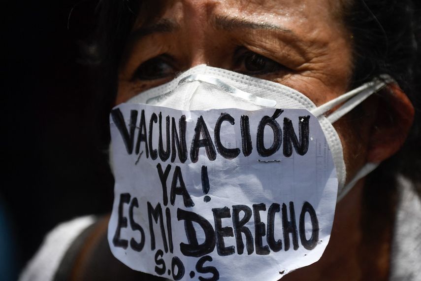 Una enfermera usa una mascarilla que dice “¡Vacunación ahora!&nbsp;Es mi derecho ”durante una protesta para exigir que todos los trabajadores de la salud sean vacunados contra el COVID-19, en la plaza Los Palos Grandes, en Caracas el 17 de abril de 2021.
