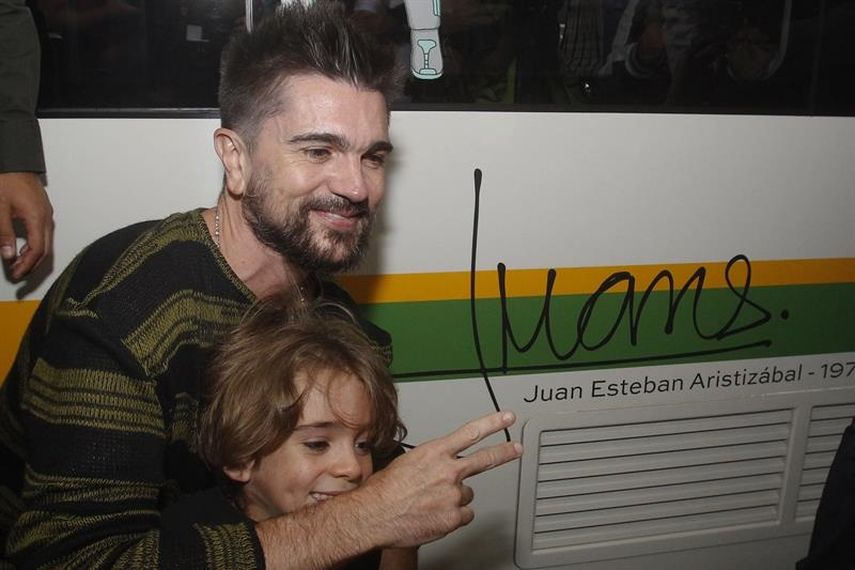 El colombiano Juanes y su pequeño hijo posan junto a la firma del cantautor. 