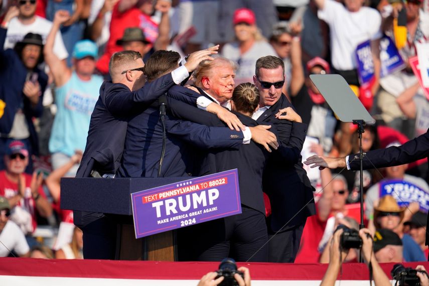 El candidato presidencial republicano y expresidente Donald Trump es ayudado a bajar del escenario en un evento de campaña en Butler, Pensilvania, donde se escucharon disparos