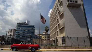 Un auto clásico pasa junto a la embajada de EEUU en La Habana, Cuba.