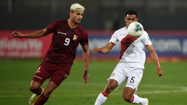 El venezolano Eric Ramírez y el peruano Marcos López compiten por el balón durante su partido de fútbol de clasificación sudamericano para la Copa Mundial de la FIFA Catar 2022