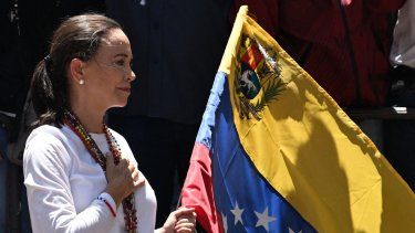 La líder opositora venezolana María Corina Machado sostiene una bandera nacional venezolana mientras hace un gesto desde lo alto de un camión durante una manifestación para protestar por los resultados de las elecciones presidenciales, en Caracas el 3 de agosto de 2024.&nbsp;