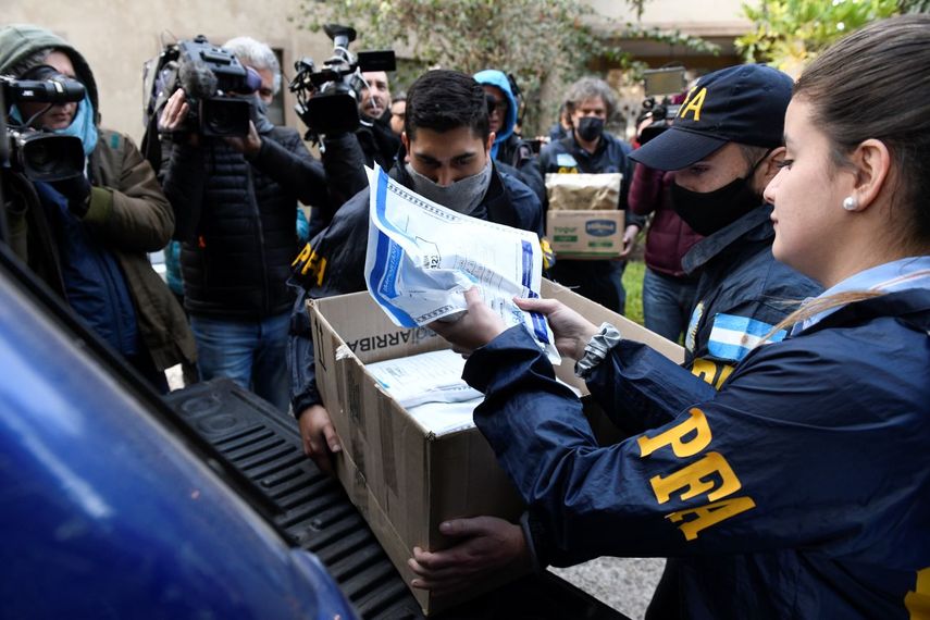 Policías confiscan una caja de documentos durante un allanamiento judicial en el Hotel Plaza Central donde se aloja la tripulación de un avión de carga Boeing 747 de propiedad venezolana, en Buenos Aires, Argentina, el martes 14 de junio de 2022