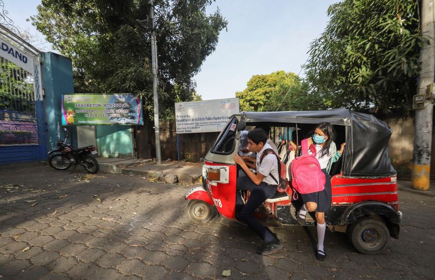 Los estudiantes llegan en un moto taxi a la escuela pública Rigoberto López Pérez, algunos con máscaras como precaución en medio de la propagación del nuevo coronavirus.&nbsp;