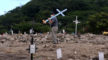 Un hombre busca la tumba de un familiar, víctima de la nueva pandemia de coronavirus, en el cementerio COVID-19, en el Día de Muertos, en Tegucigalpa, Honduras, el 2 de noviembre de 2020. 