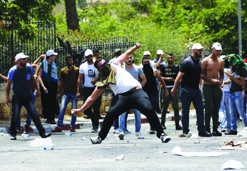 Palestinos tiran piedras a la Policía israelí.
