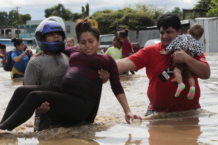 En esta fotografía de archivo del 5 de noviembre de 2020, una mujer embarazada es sacada de un área inundada por el agua traída por el huracán Eta en Planeta, Honduras. Los huracanes que han azotado Centroamérica han supuesto un fuerte obstáculo para la Organización Panamericana de la Salud y su lucha contra el COVID-19 ya que han dañado a más de 640 centros de salud, reducido al personal médico local y aumentado el riesgo de contagio en abarrotados refugios.