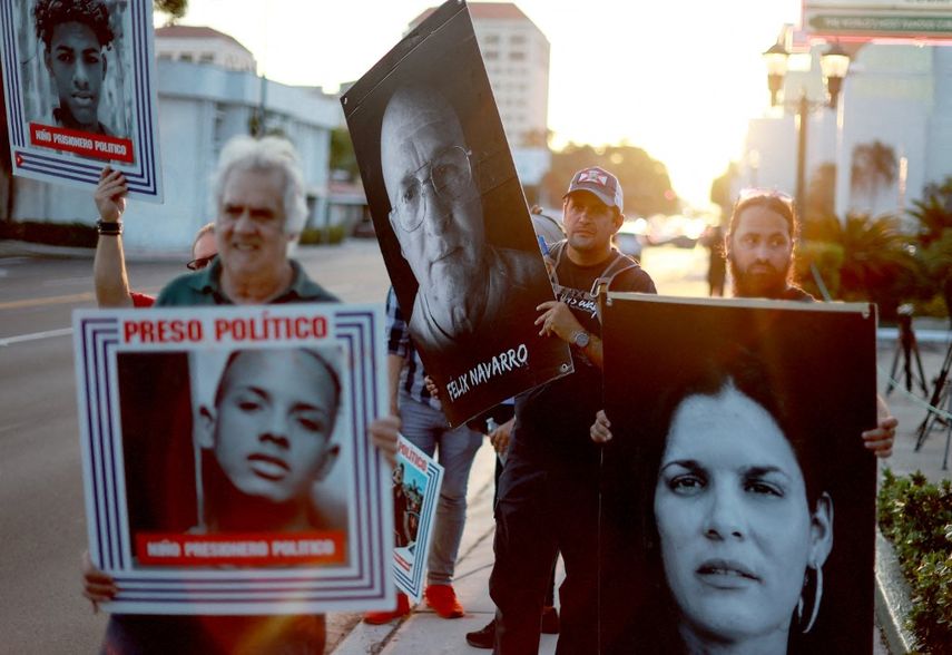 La gente sostiene fotografías de presos políticos recluidos en cárceles cubanas durante una manifestación en apoyo a los manifestantes en Cuba el 18 de marzo de 2024, en Miami, Florida.